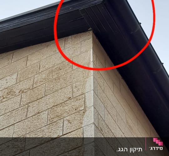 גג עם רעפים שחורים על קיר לבנים בזווית בניין